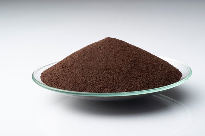 Close-up of LANXESS Iron Oxide Brown 4668 powder on a glass plate.